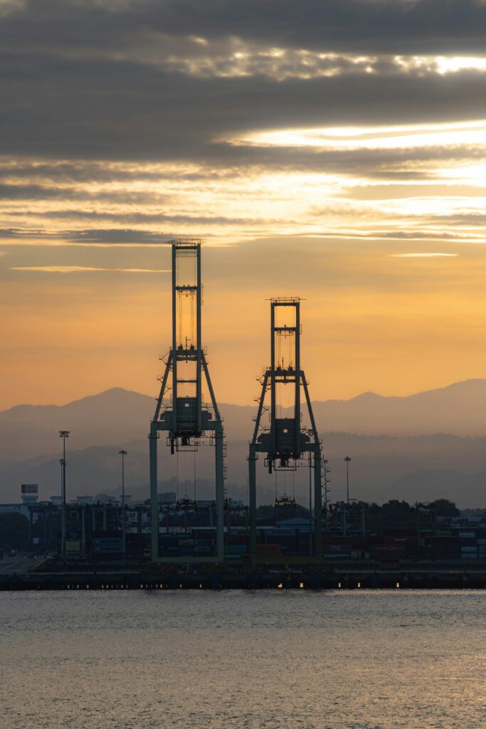 Serene sunset view of cargo cranes at Penang Port, Malaysia highlighting industrial beauty against nature.